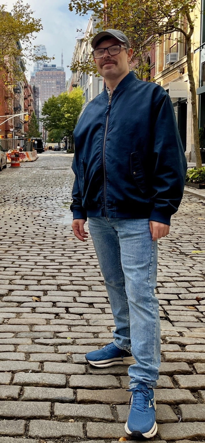 Elazar Hoch standing on a cobblestone street in New York City.
